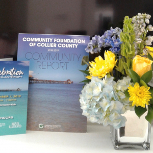 Table setting with Celebration of Philanthropy brochure and Collier County Community Report