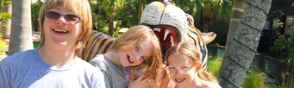 Three smiling children near tiger statue