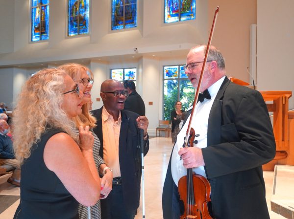 Violinist speaking with audience in church
