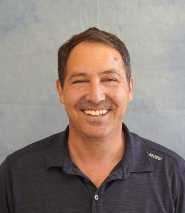 Smiling man wearing a dark polo shirt