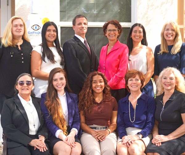 Group of smiling professionals posing outdoors.