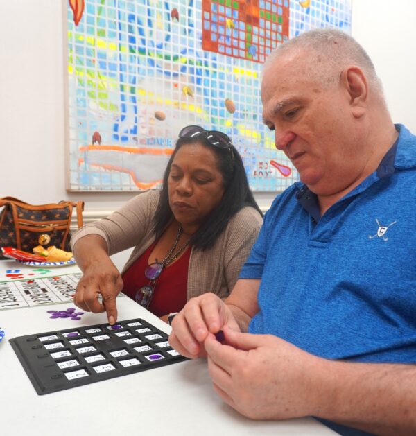 Woman assisting man with bingo board