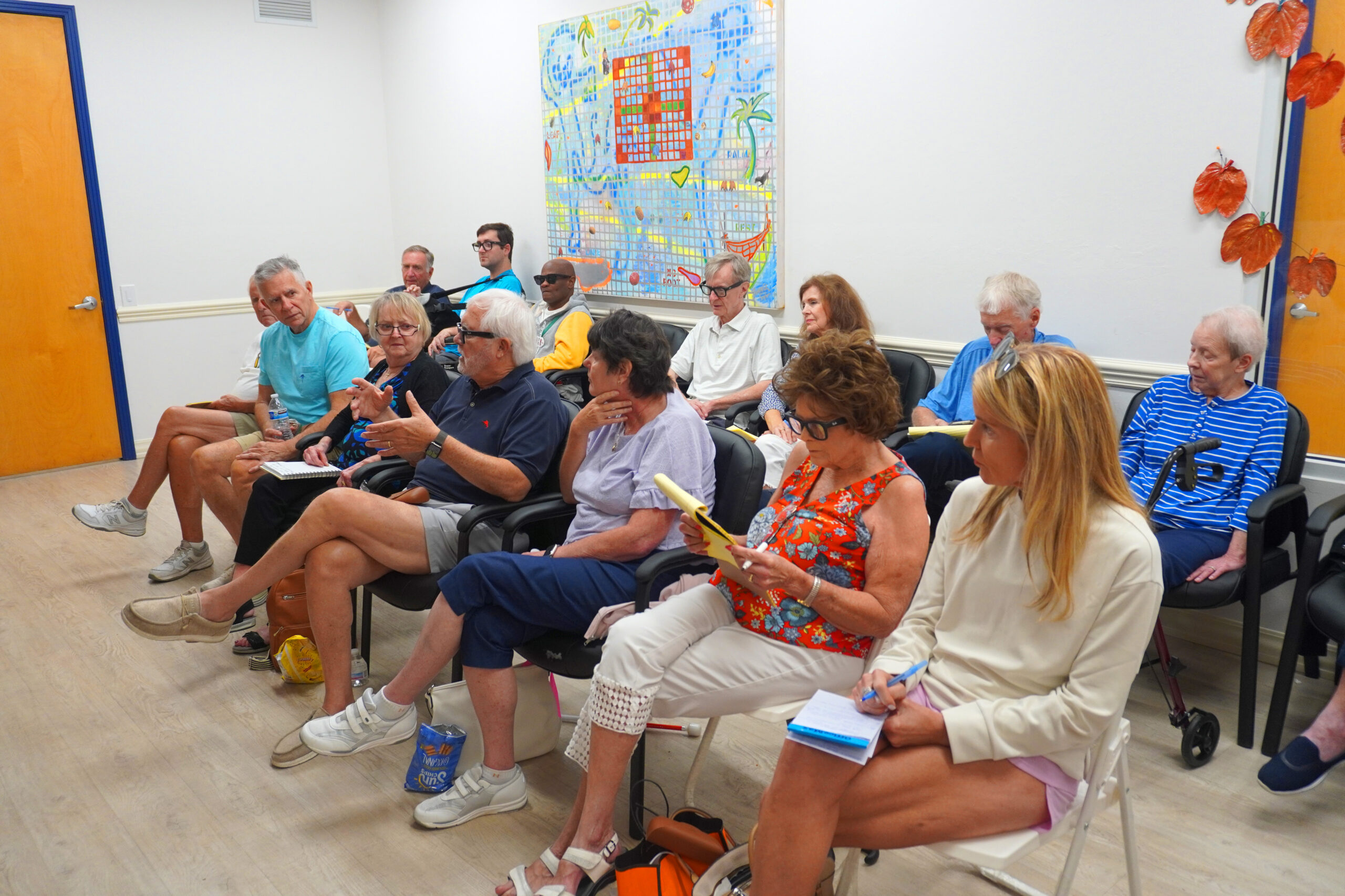 Seniors attending community meeting taking notes